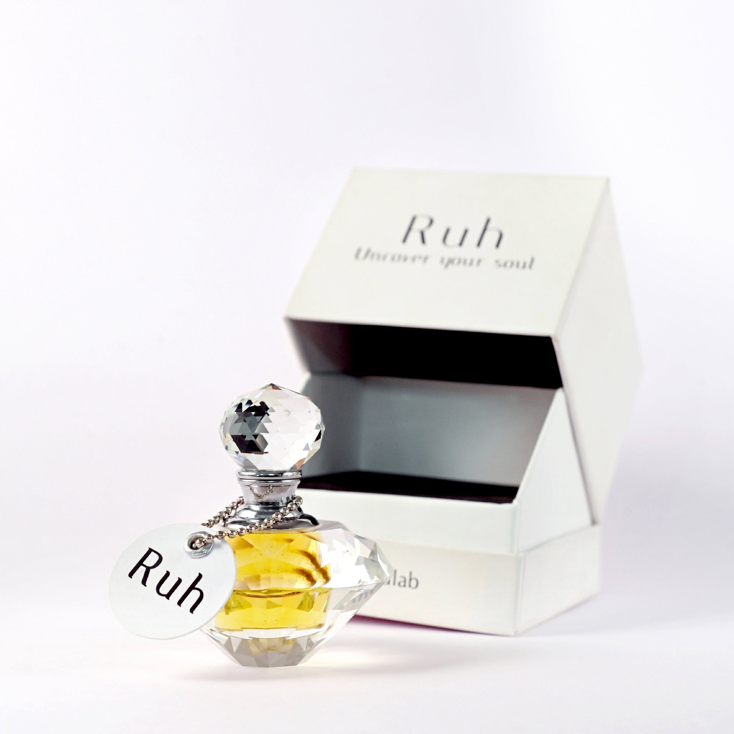 diamond cut crystal bottle of ruh gulab attar with minimal designed elegant black-and-white box
